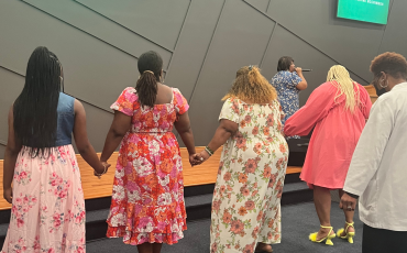 Women at a church altar holding hands in worship